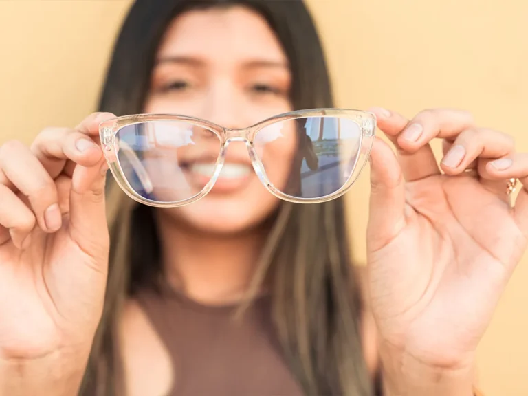 Ragazza che tiene in mano degli occhiali da vista